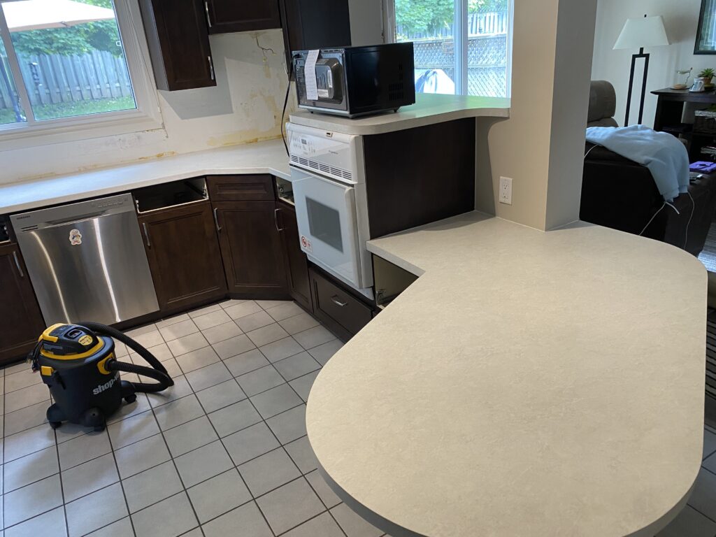 Modern kitchen with dark cabinets and white countertops.