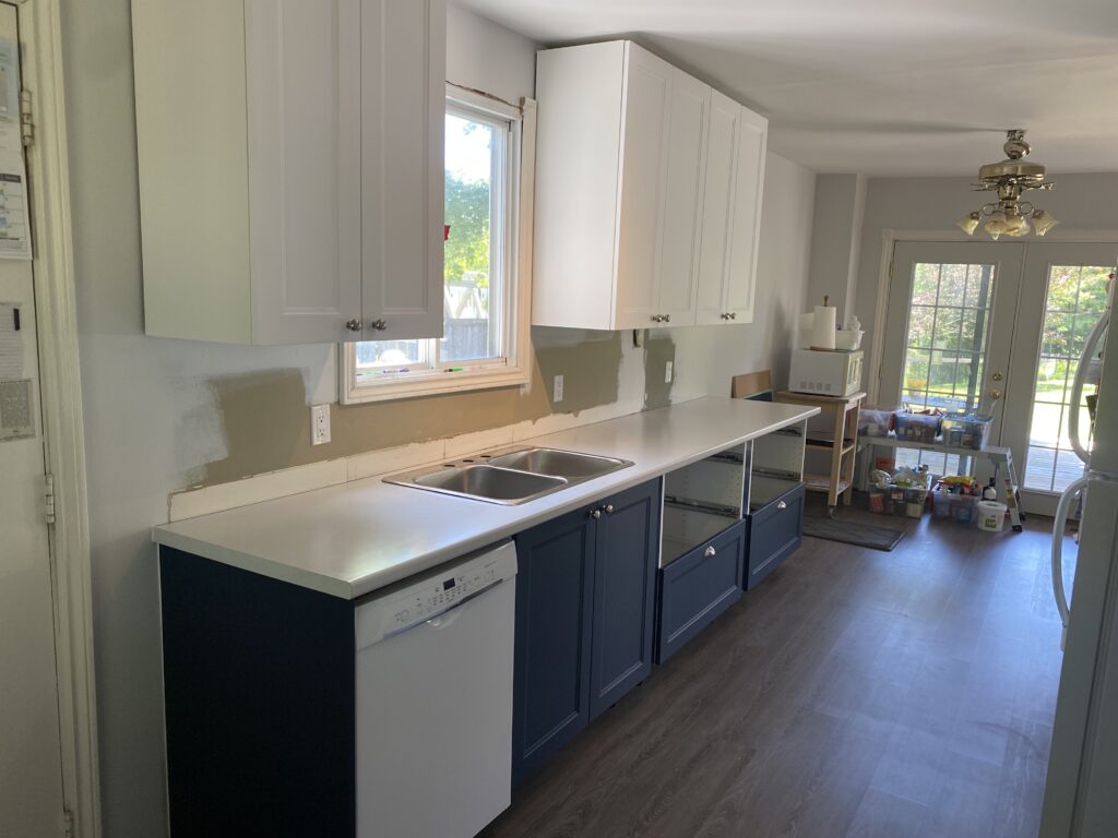Modern kitchen with white upper cabinets and navy blue lower cabinets.