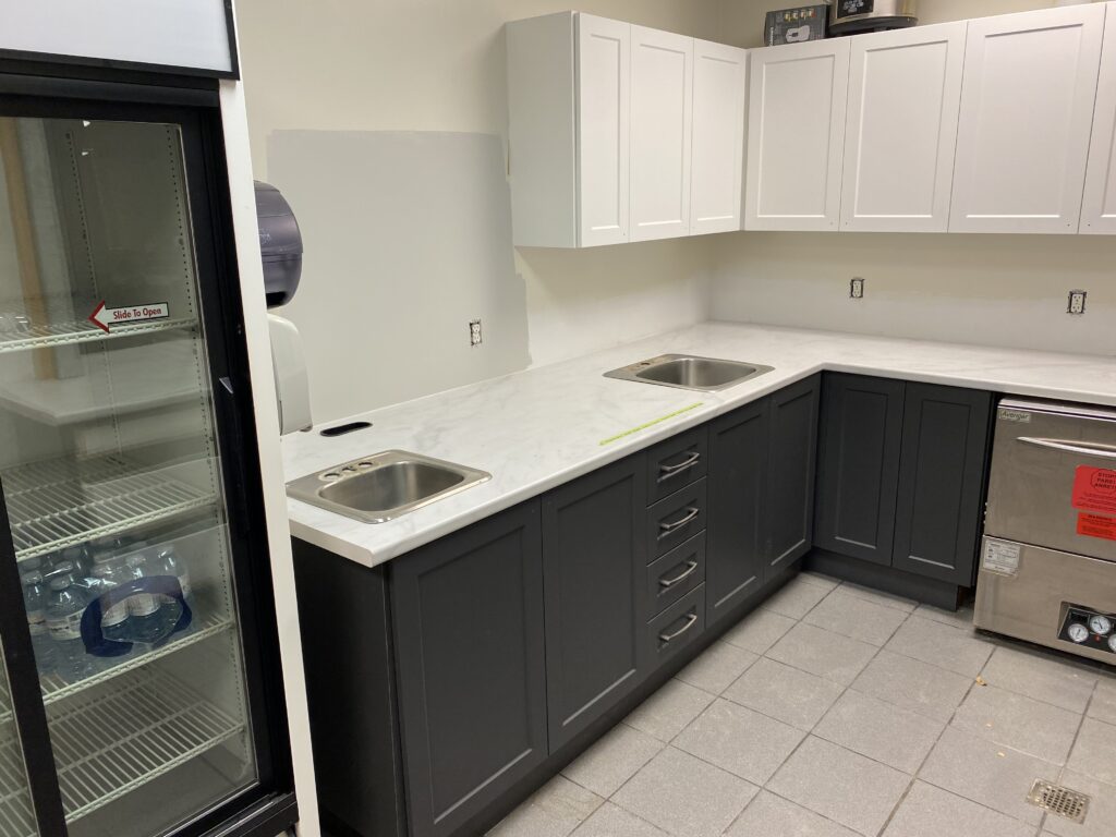 Modern kitchen with black lower cabinets and white upper cabinets.