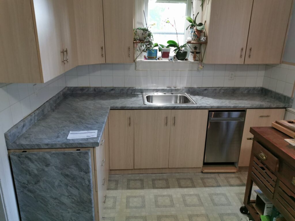 Modern kitchen with granite countertops and wooden cabinets.