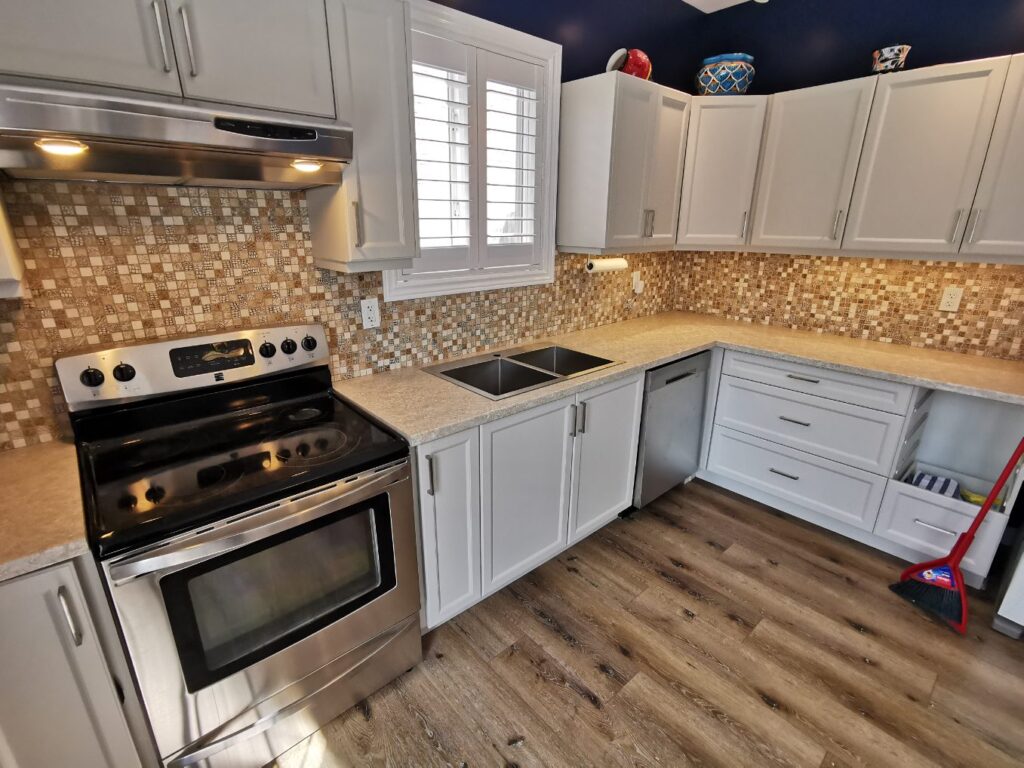 Modern kitchen with stainless steel stove and mosaic tile backsplash.