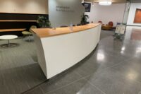 Modern business lounge with curved reception desk.