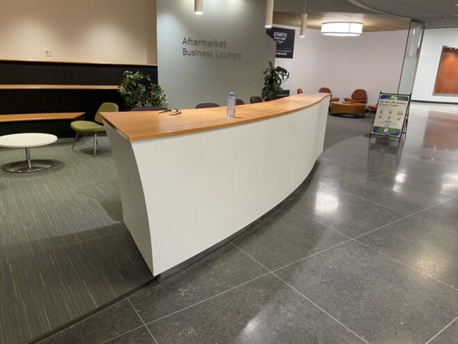 Modern business lounge with curved reception desk.
